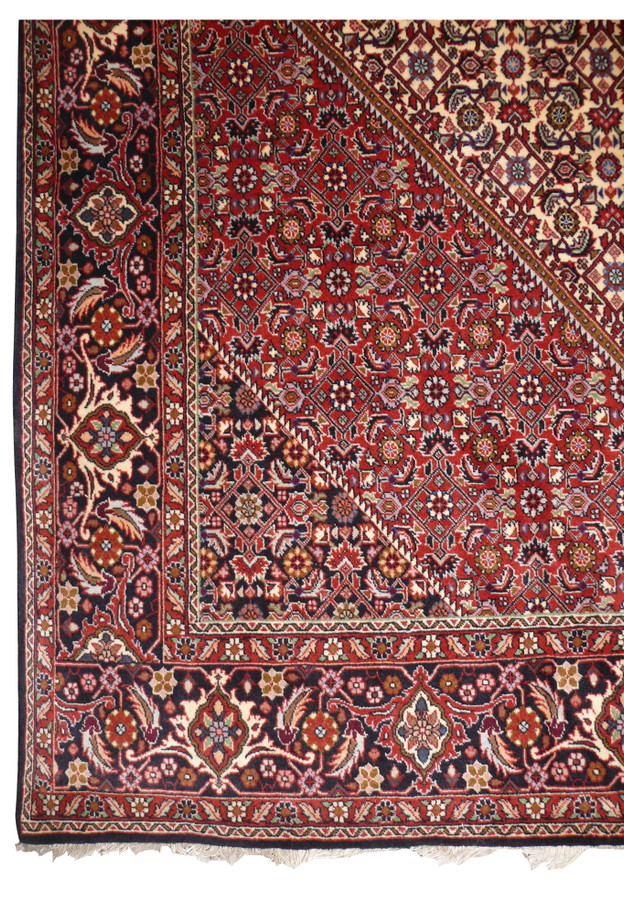 Corner detail of 7x10 Persian Bijar with brick red spandrel meeting navy palmette border and ivory guard stripes