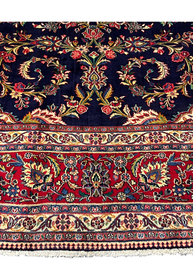 Lower spandrel detail of 10x13 Qum kork rug, ivory corner cartouche with dense palmette and curling vine on navy ground