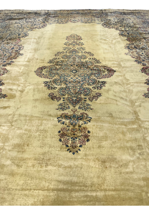 Central medallion close-up of Persian Kerman rug, sky blue and dusty rose cartouches with miniature palmettes