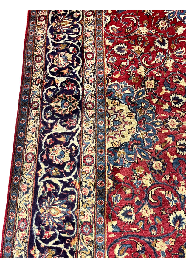 Border closeup Persian Isfahan rug, palmette and vase motifs on saturated indigo, fine wool pile on cotton foundation handmade in Persia