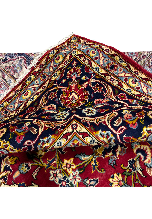 Folded edge of Persian Kashan rug, fine knotting visible on reverse, authentic handmade wool on cotton for formal traditional interior