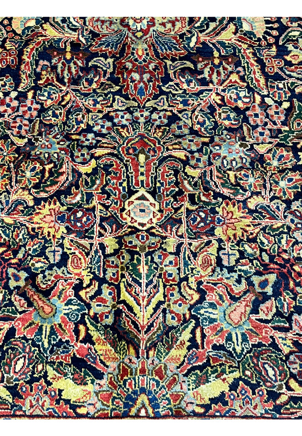Navy field pattern close-up showing weeping boteh and cypress-like terminals on antique Sarough rug