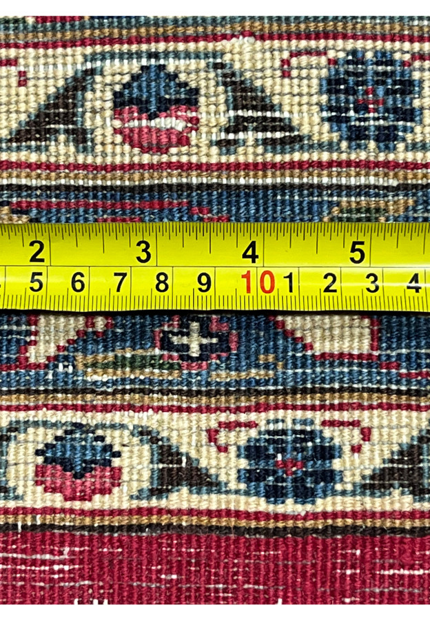 Backside knot measurement of vintage Mashad rug, ruler confirming fine hand knotted wool construction