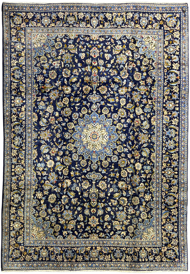 Full view of 8x11 navy Persian Kashan rug with ivory medallion and multilayered floral border