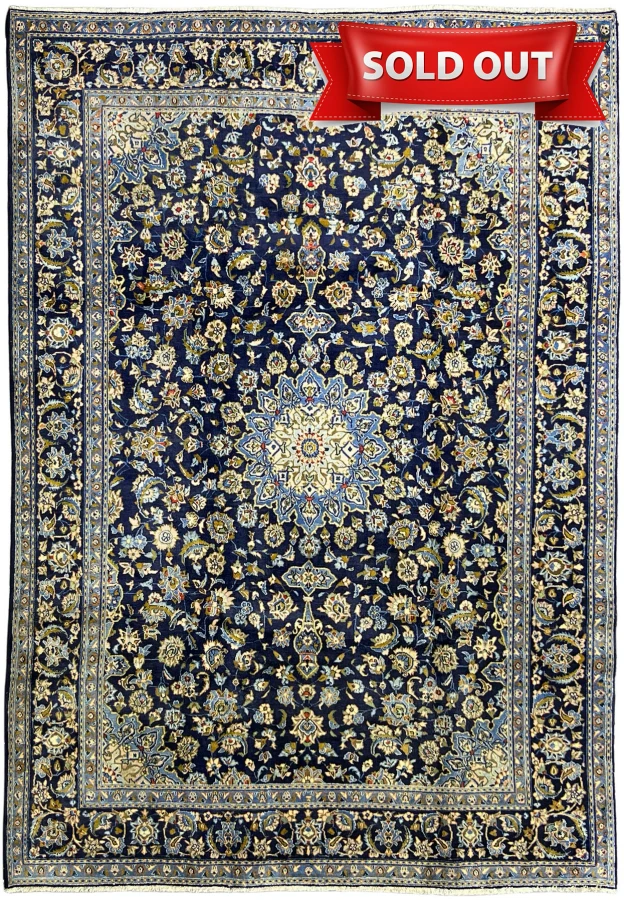 Full view of 8x11 navy Persian Kashan rug with ivory medallion and multilayered floral border