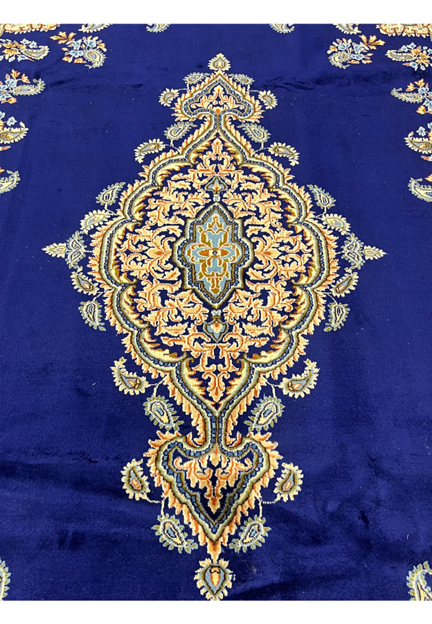 Central elongated floral medallion of Persian Yazd rug, peach and gold palmettes with sky blue diamond center on navy