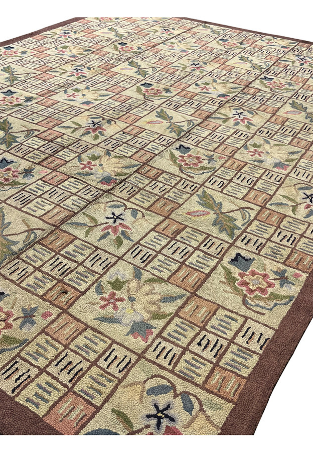Angled view across the 9x12 patchwork rug highlighting cream salmon and sage green tiles