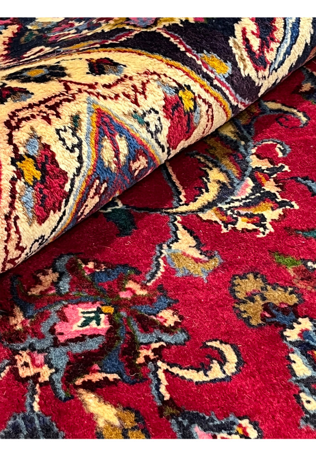 Folded section of the Mashad revealing the plush velvety wool pile and crisp drawing