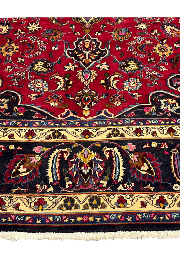 Lower border of the Mashad showing navy boteh paisleys between butter yellow guard bands