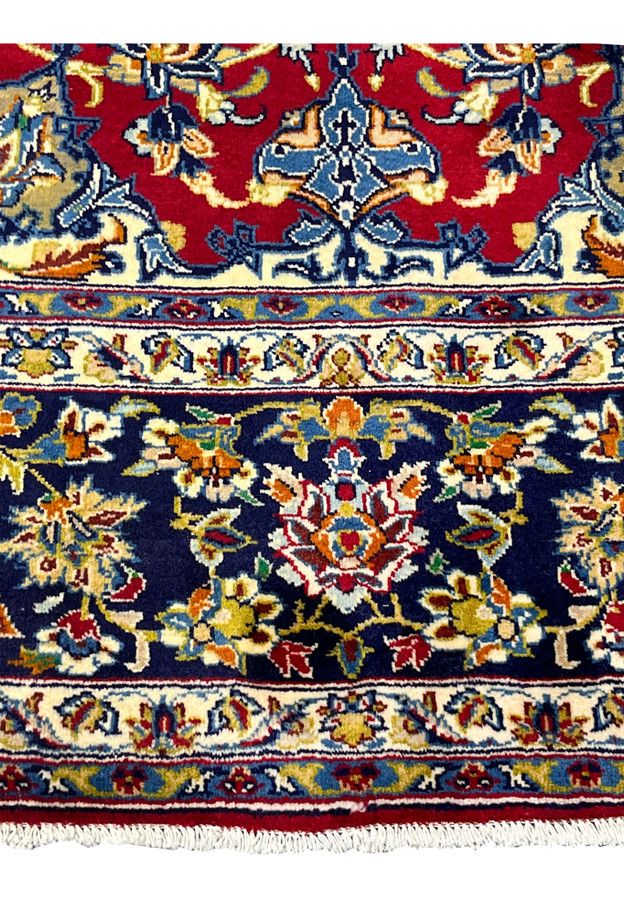 Lower border of the red Najafabad with navy floral band and ivory arabesque guards