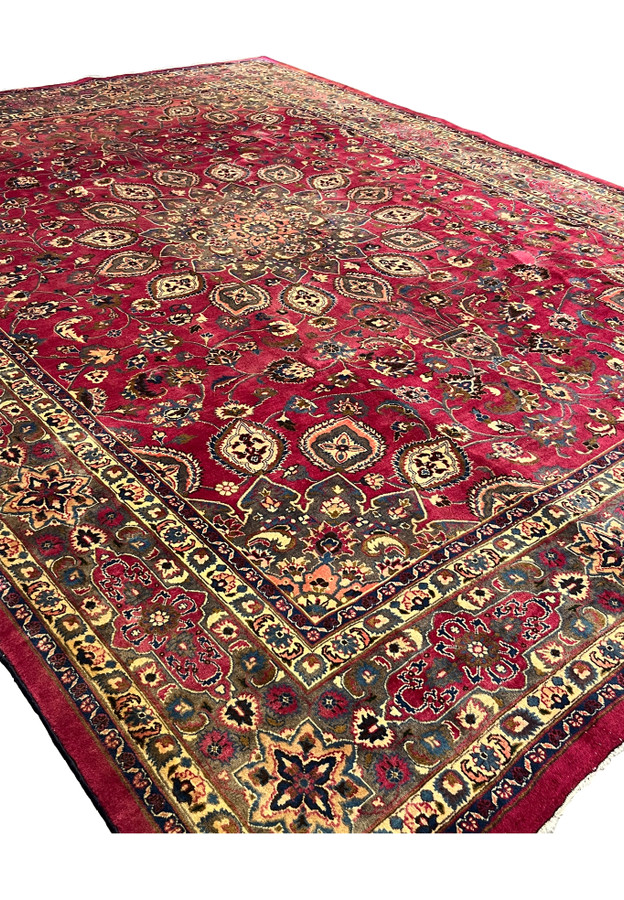 Angled view of the 10x13 Persian Mashad rug showing its rich raspberry red all-over floral field