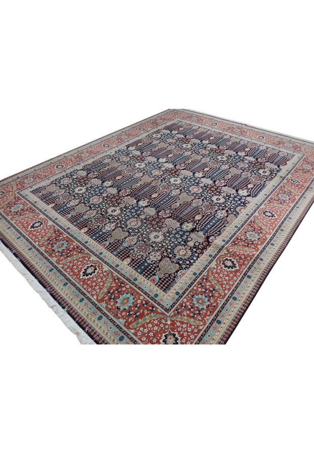 Angled view of the 10 x 13 Tabriz showing its navy vase field and brick-red turtle border