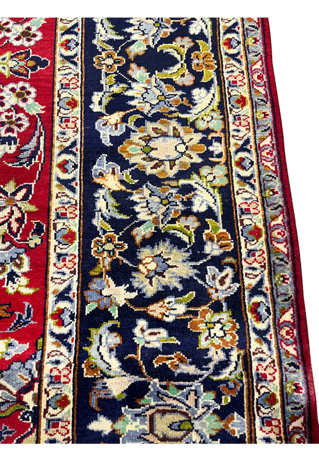 Indigo border close-up revealing a small woven bird among scrolling flowers, a charming Najafabad detail.