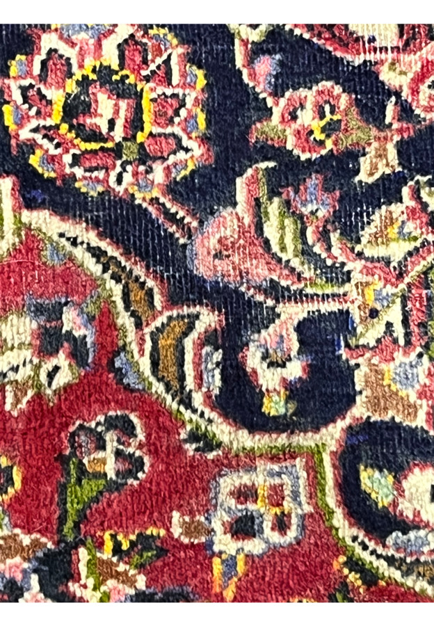 Natural abrash in the navy ground, gentle tonal shifts from hand-dyed wool, a sign of authenticity.