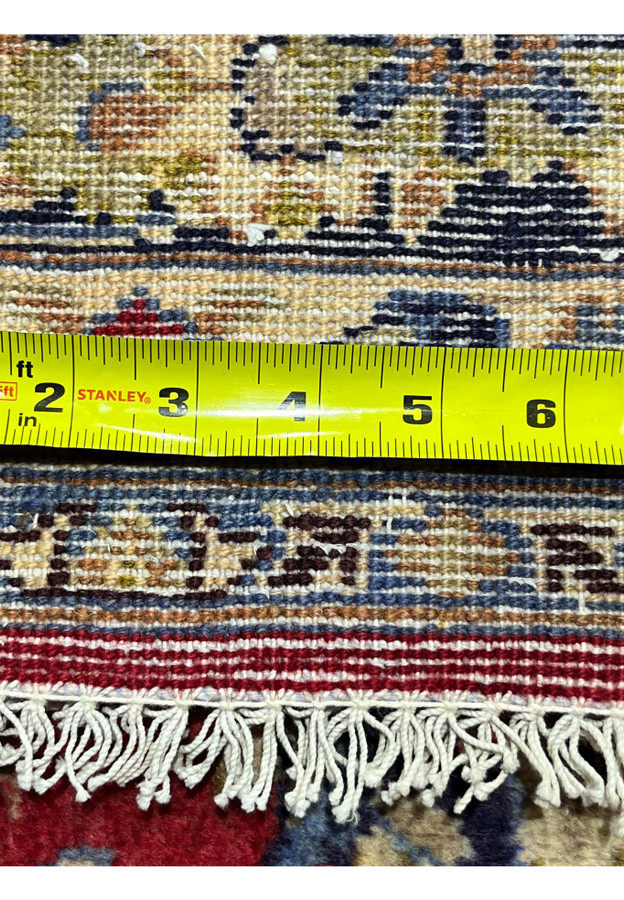 Tape measure across the back confirming the knot density of this 9x13 Najafabad floor rug.