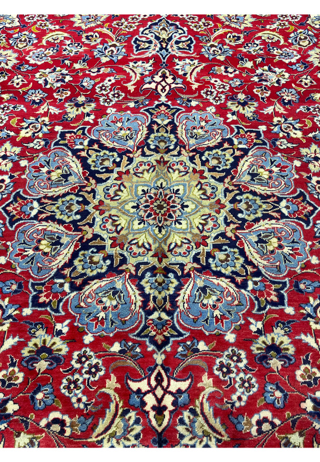 Ivory and navy center medallion surrounded by sky blue palmettes and red floral tracery.