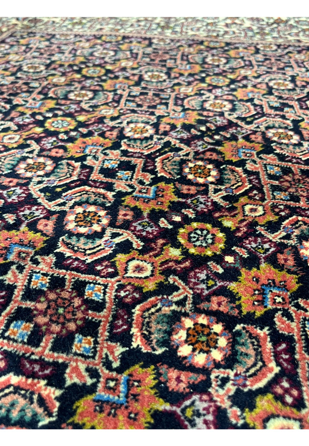 Field detail of the allover Herati lattice in rose red and navy on this Persian Bijar.