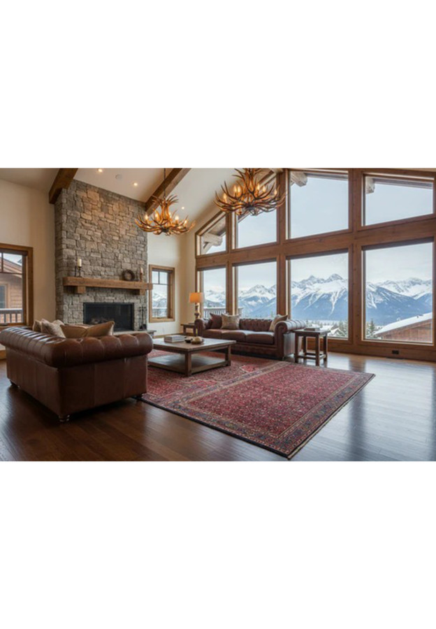 Antique red Bijar rug anchoring a mountain-view living room with leather chesterfield sofas