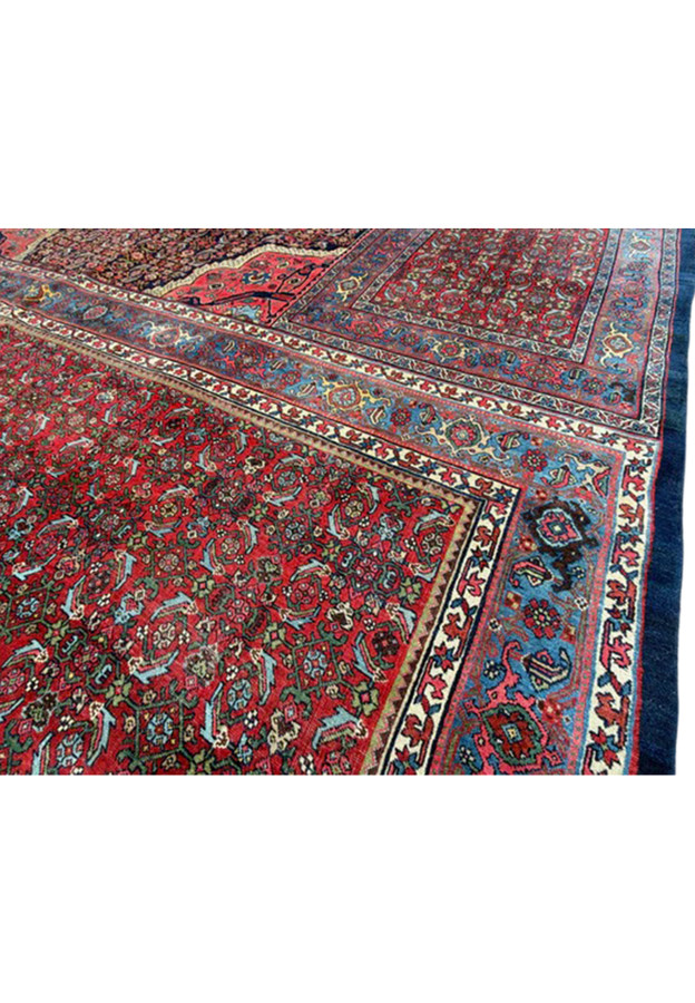 Close view of the dense hand-knotted wool pile, red field and blue floral border