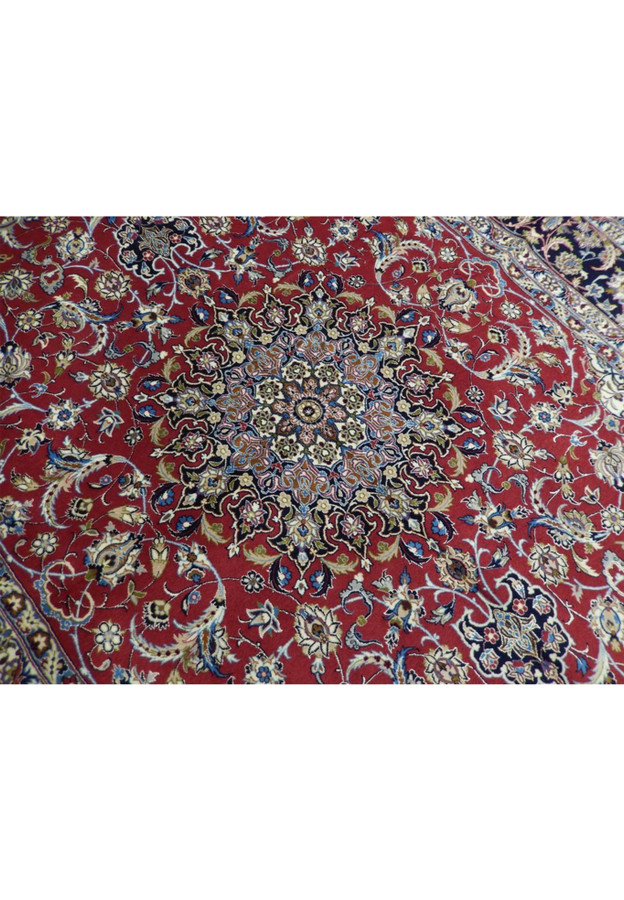 Layered star medallion detail with light blue and ivory arabesques radiating over red ground