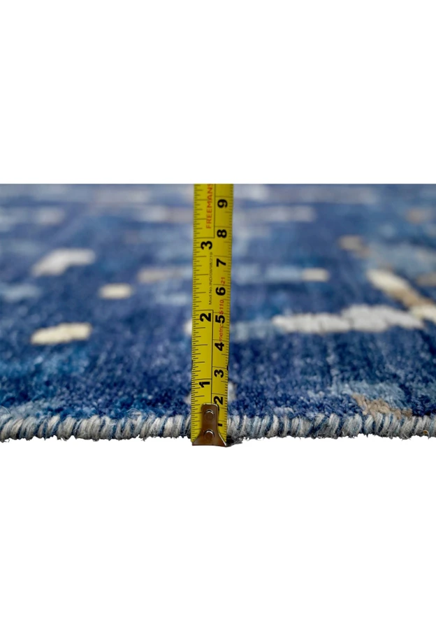 Tape measure at rug edge showing comfortable plush pile height of brand new hand knotted modern wool and silk area carpet
