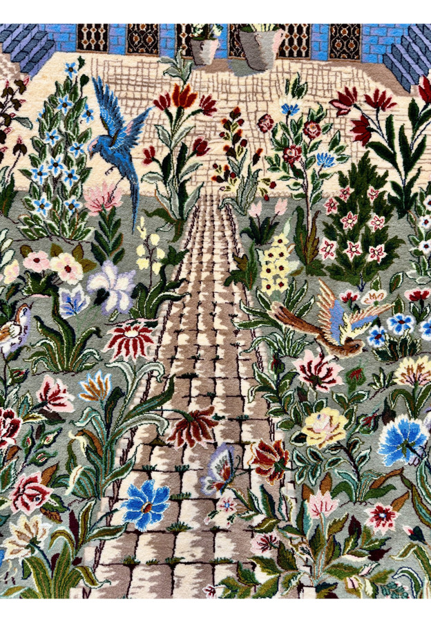 Cobblestone garden path bordered by sage green flowerbeds, tulips, irises and a soaring blue bird