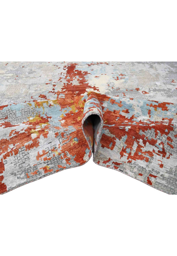 Burnt orange and silver grey abstract rug folded to show front pile and finished back