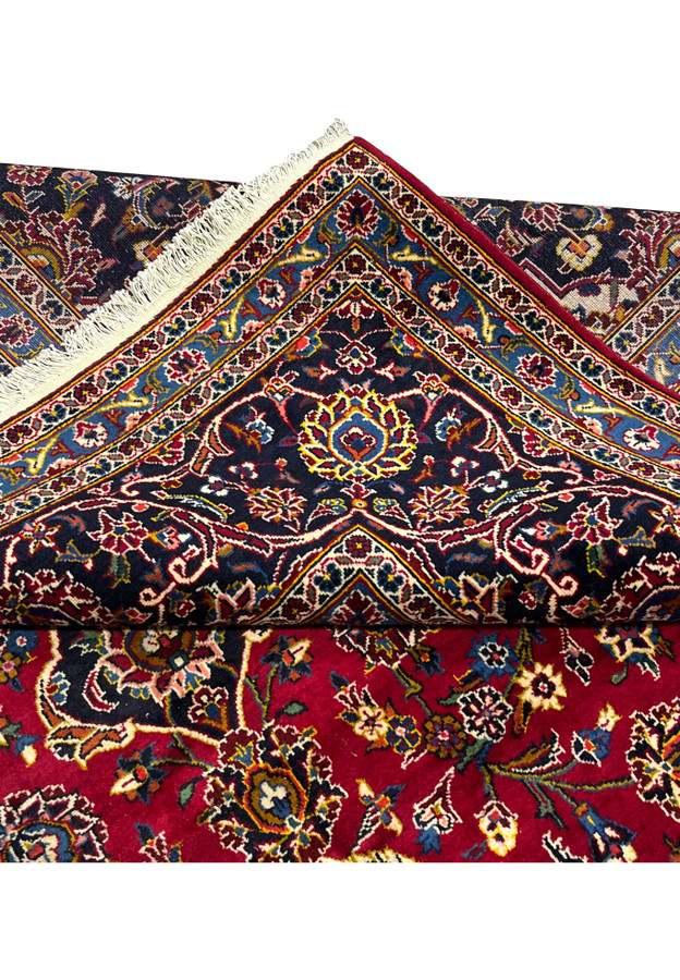 Folded corner revealing the woven back alongside the navy and ivory border front