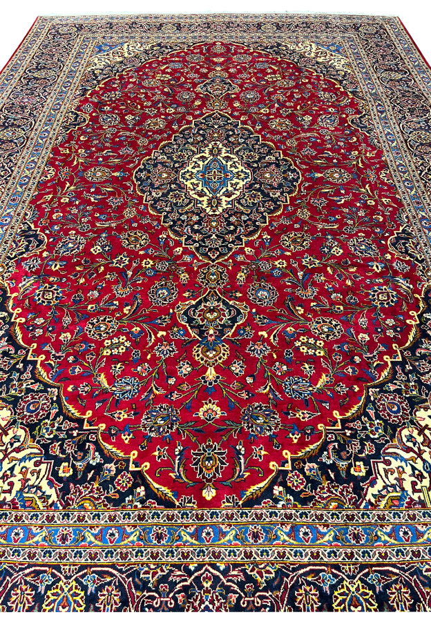Red field densely covered in floral vines, rosettes and palmettes in ivory, blue and gold