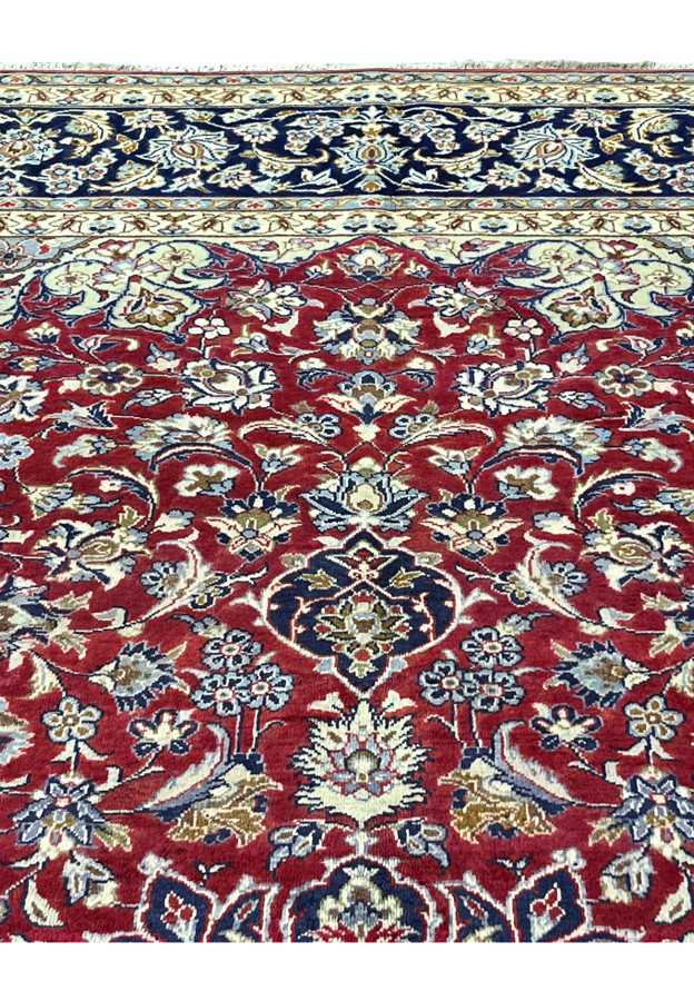 Upper section of the rug where the navy border meets the flowering red ground