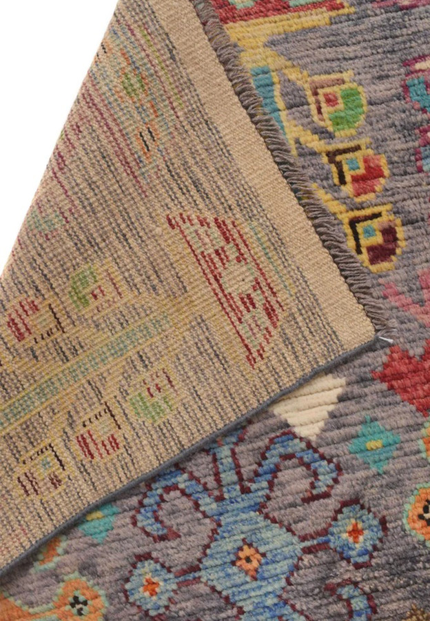 Reverse of the hand-knotted Gabbeh rug revealing dense wool knots and multicolor tribal design bleeding through