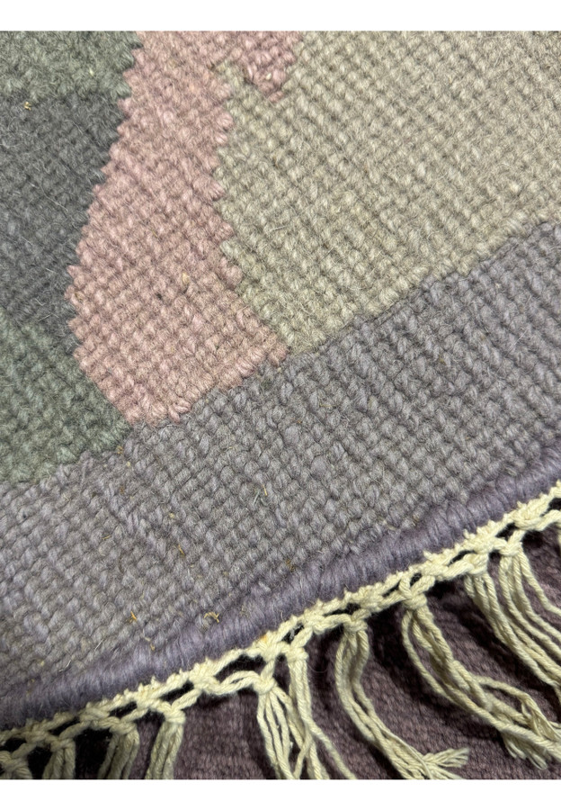 7'3 round Nepali rug reverse showing hand-knotted wool weave, pastel border and cream fringe
