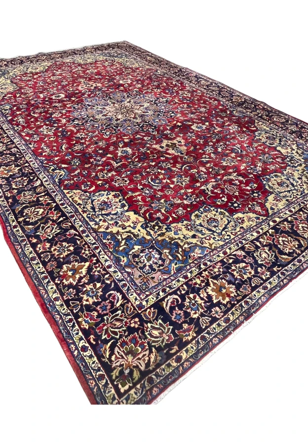 10x16 Persian Najafabad oversize rug at an angle, red field with a blue medallion and cream corners