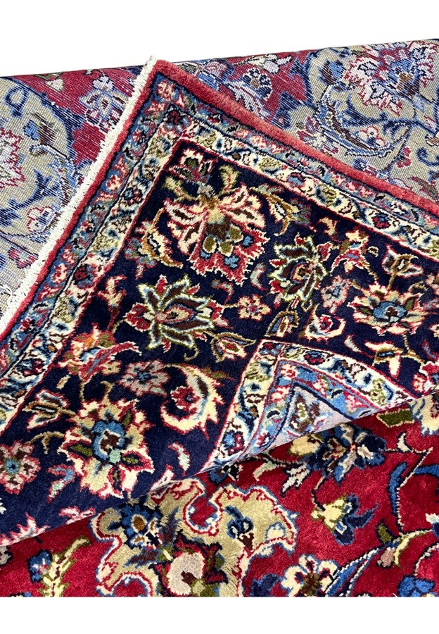Folded corner showing the reverse of the hand-knotted Najafabad rug and its ivory fringe