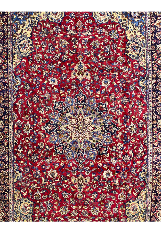 Close-up of the red field with fine floral vines and blossoms in blue, ivory and gold