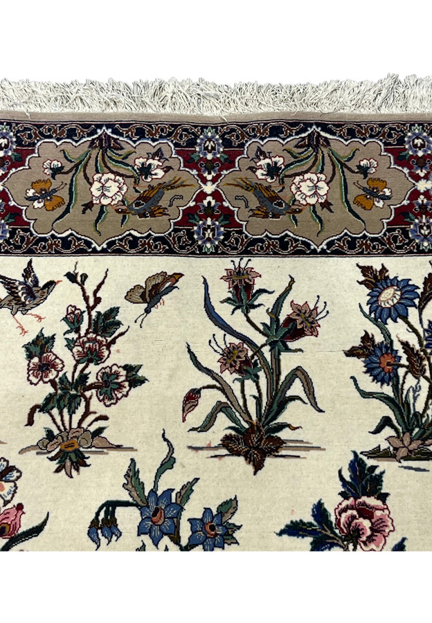 Upper field of the 4x6 Isfahan rug where the border cartouches meet the ivory ground