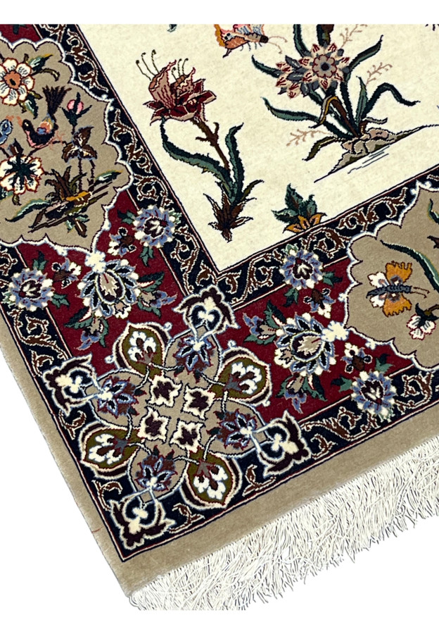 Corner and silk fringe of this hand-knotted Isfahan rug with navy scroll guard bands