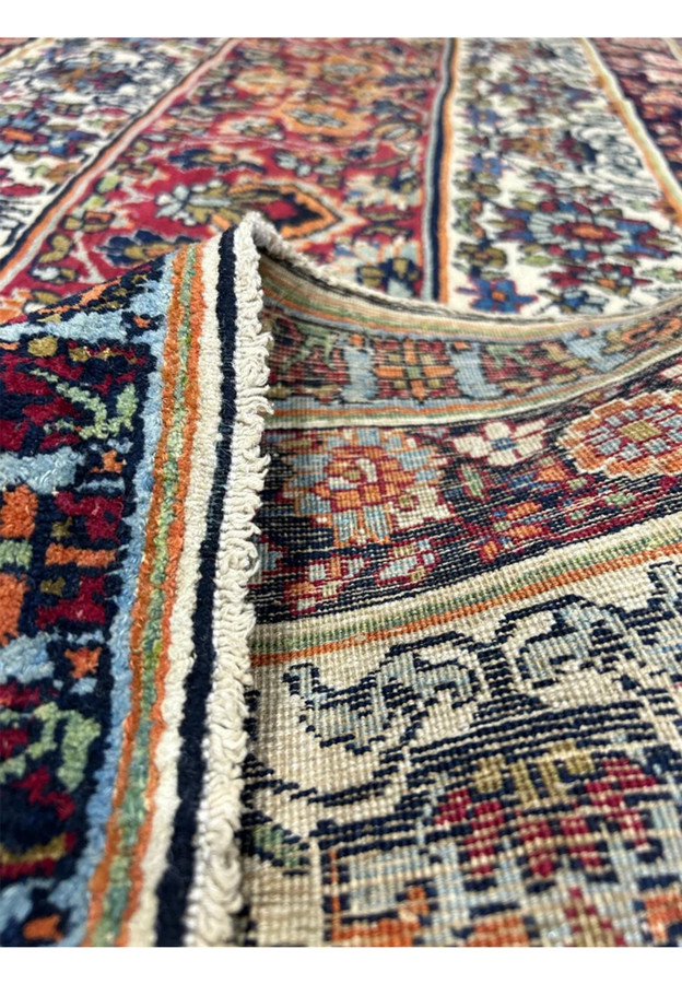 Back of the antique Kermanshah showing the knot grid over a cotton foundation