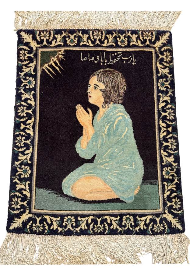 Small Tabriz pictorial rug laid flat showing kneeling girl in blue robe on dark field