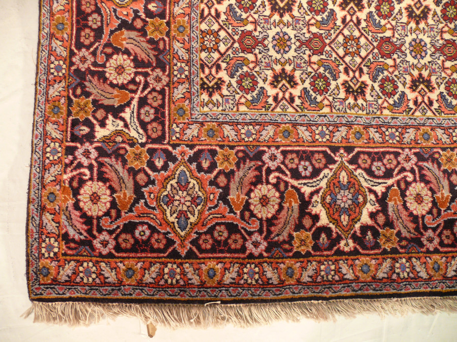 Detailed close-up of Persian Bijar rug corner, revealing tight knotting and navy-blue Mahi motifs with beige and olive accents.