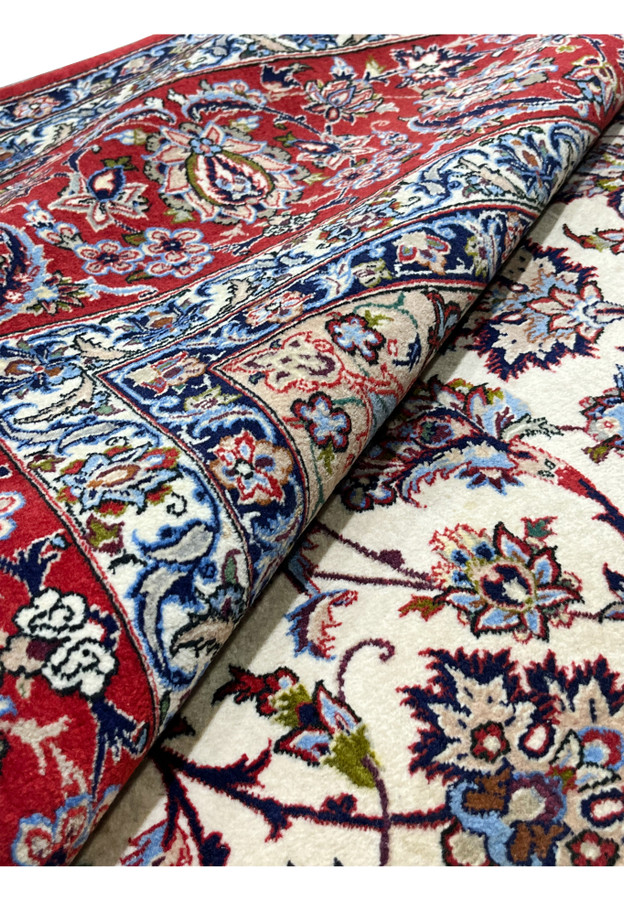 Rolled 8x12 premium Persian Isfahan wool silk rug showing pile depth crimson red border ivory field silk sheen handmade
