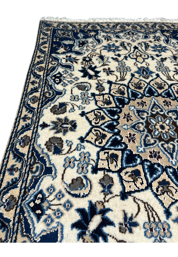 Midfield floral design of Persian Nain rug with wool and silk pile.