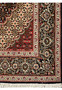 A Persian Tabriz Mahi rug's border detailed with navy blue, olive green, pink, and cream designs on a dark brown background