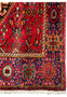 Corner detail of a 4x6 Persian Gholtogh rug highlighting the red and blue motifs