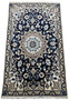 Full view of a Persian Nain rug displaying the sophisticated medallion and border designs against a deep navy blue field