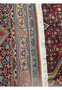 A close-up view of the side border of the Persian Bijar rug, showcasing the detailed geometric and floral patterns against a red backdrop.