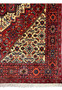 Corner detail of Persian Gholtogh rug with tassels and precise border pattern