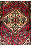 Close-up of the central medallion and floral patterns on a Persian Hamedan rug against a crimson background