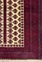 Close-up of the prayer rug's border patterns, showcasing the traditional Baluch tribal designs