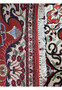 Edge of a Persian Qum silk rug with a close-up on the tightly-knotted fringe and border design showing that the back almost looks identical to the front of the rug